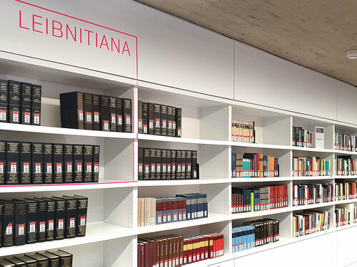 Weißes Bücherregal mit der Beschriftung Leibnitianer