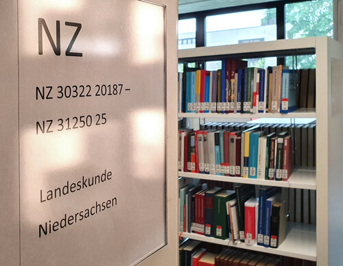 Auf der linken Seiten steht eine Information mit dem Themenbereich. Hier NZ für "Niedersachsen". Im Hintergrund steht ein Bücheregal.