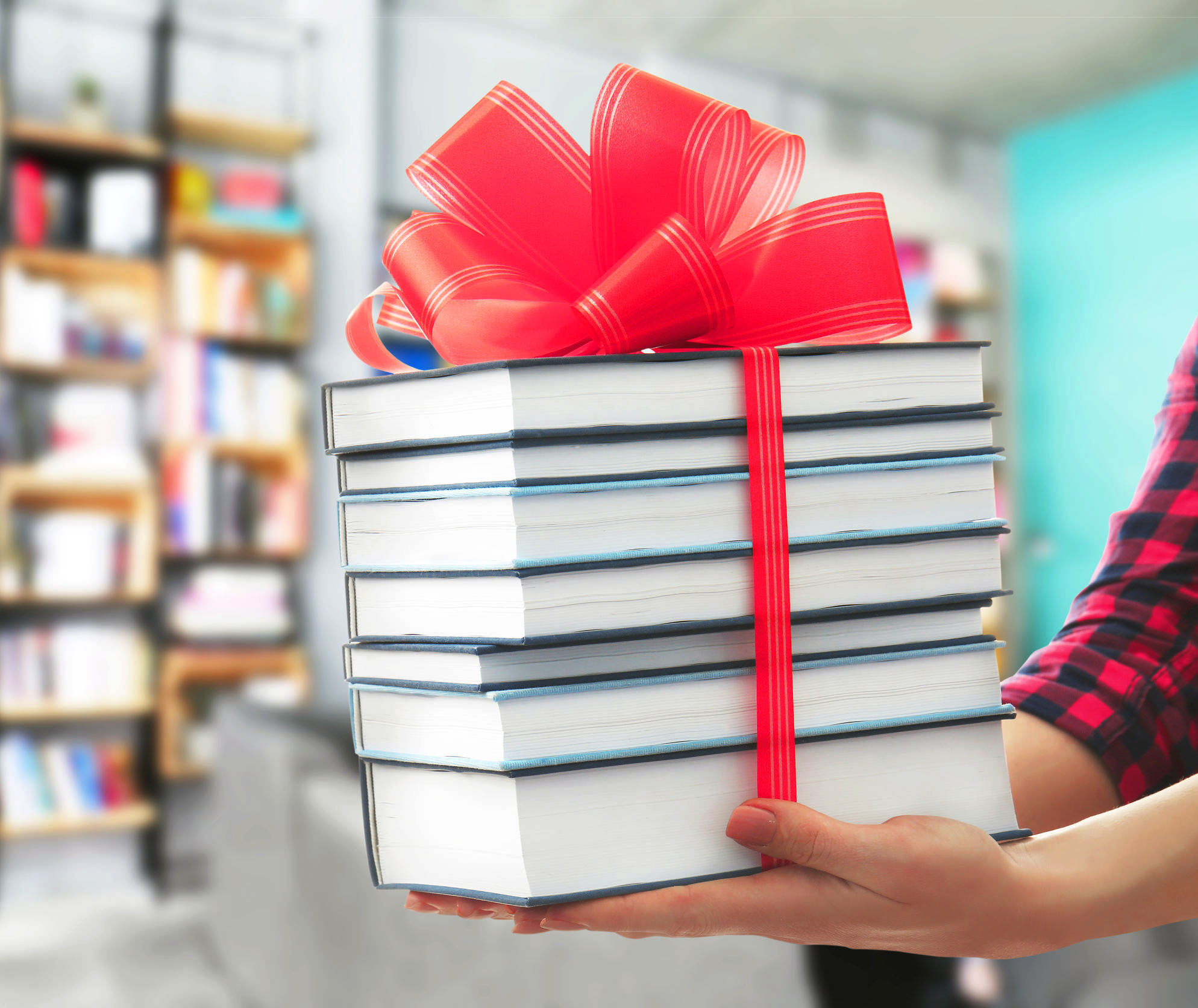 Ein Bücherstapel mit einer großen, roten Geschenkschleife verpackt.